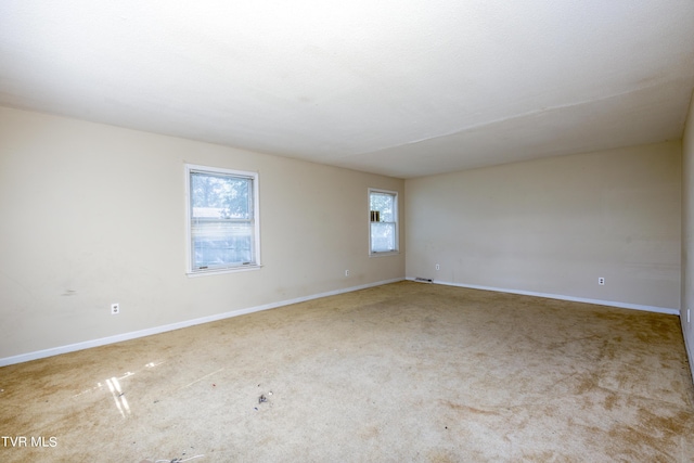 carpeted spare room featuring visible vents and baseboards