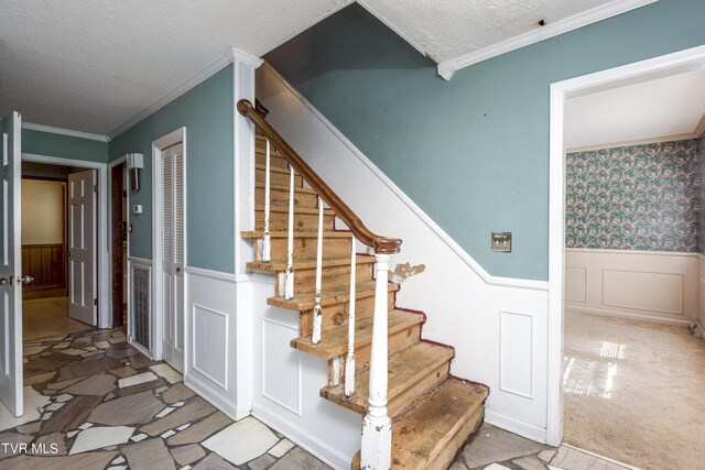 stairs featuring carpet, crown molding, and a textured ceiling