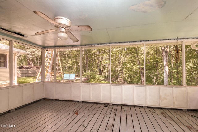 unfurnished sunroom with ceiling fan