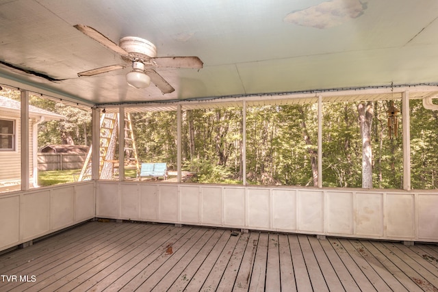 unfurnished sunroom featuring plenty of natural light and a ceiling fan