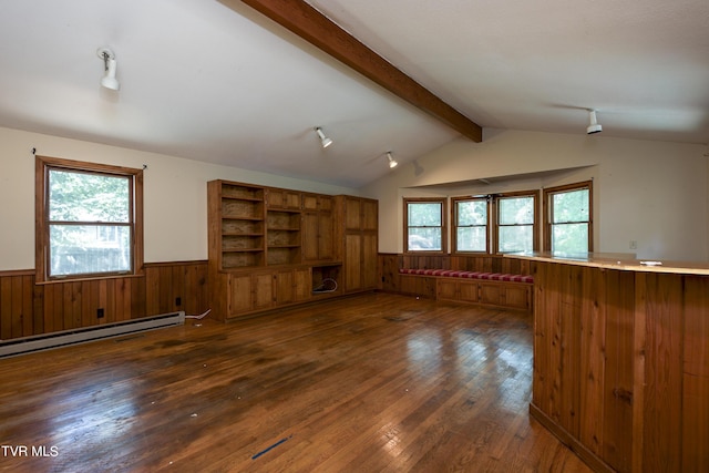 unfurnished living room featuring a wainscoted wall, lofted ceiling with beams, a baseboard heating unit, wooden walls, and dark wood-style flooring