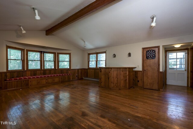 unfurnished living room with a wealth of natural light, dark wood-type flooring, a baseboard heating unit, and lofted ceiling with beams