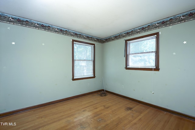 spare room with a healthy amount of sunlight, baseboards, and light wood finished floors