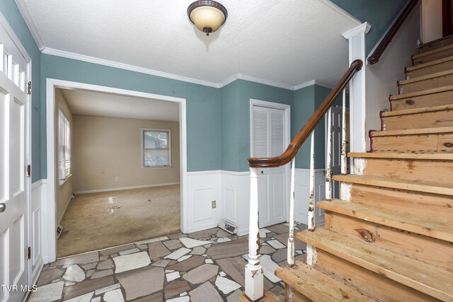 foyer with plenty of natural light, light carpet, and a textured ceiling