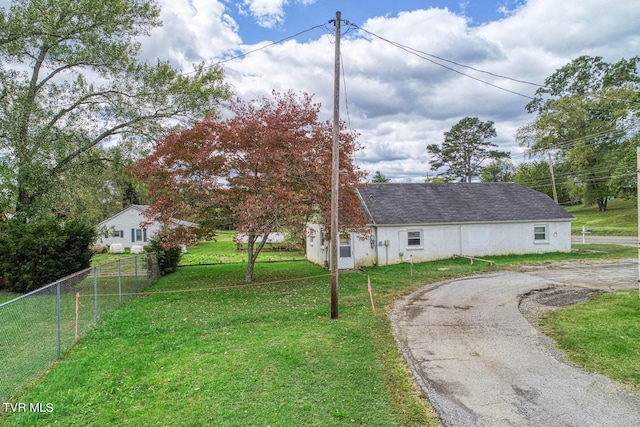 view of front facade featuring curved driveway, fence, and a front lawn