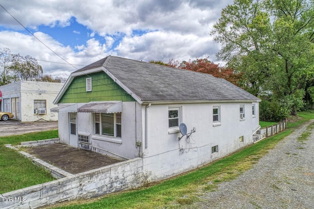 view of home's exterior featuring roof with shingles and stucco siding