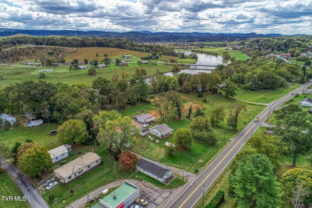 drone / aerial view with a water and mountain view and a rural view