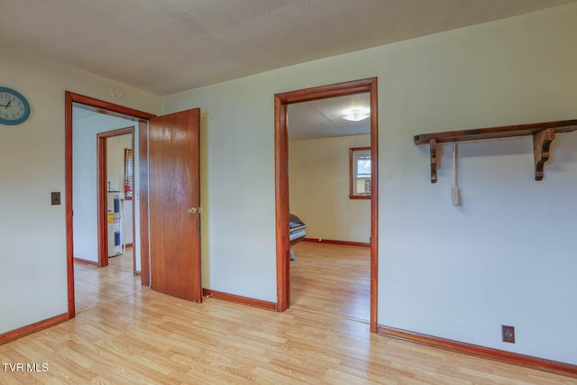 unfurnished room featuring a textured ceiling and light wood-type flooring