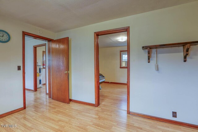 spare room featuring light wood-style floors and baseboards