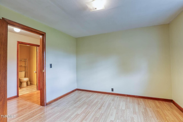 unfurnished room with baseboards and light wood-style flooring