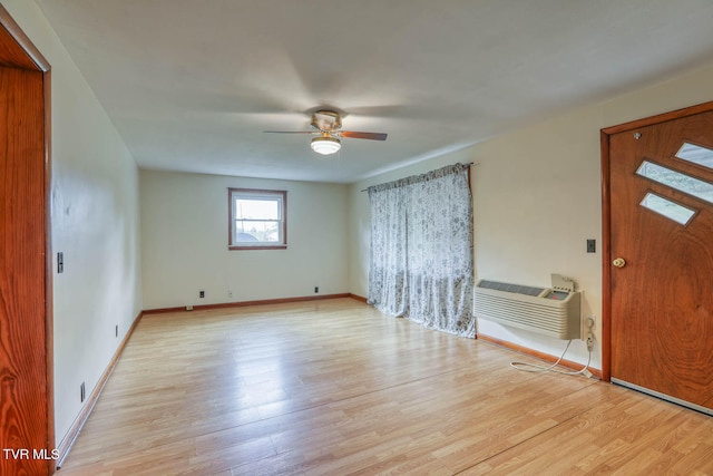 foyer entrance featuring light hardwood / wood-style floors, a wall unit AC, and ceiling fan