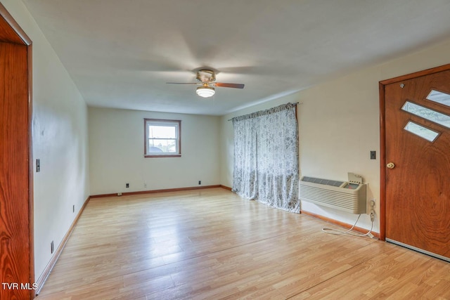 foyer entrance with light wood-style floors, baseboards, ceiling fan, and an AC wall unit