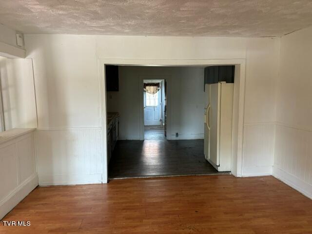 unfurnished room featuring hardwood / wood-style flooring and a textured ceiling