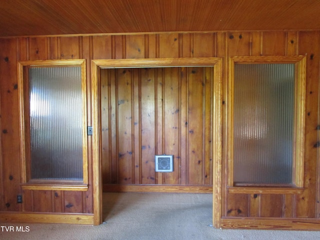 interior details featuring wooden ceiling, carpet floors, and wooden walls