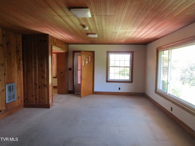 unfurnished bedroom featuring wooden walls, wood ceiling, and light carpet