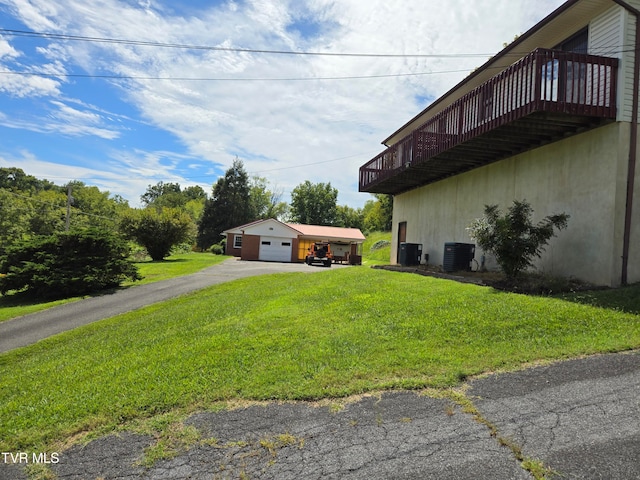 view of yard with an outdoor structure, a garage, and cooling unit