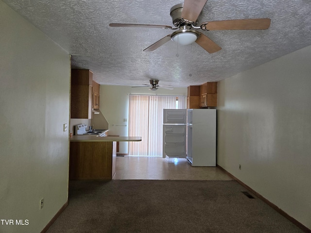 kitchen featuring white fridge, ceiling fan, and a textured ceiling