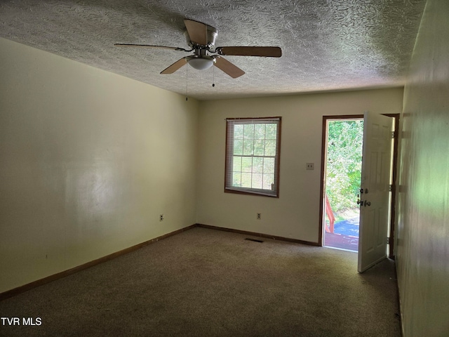 spare room with ceiling fan, carpet, and a textured ceiling