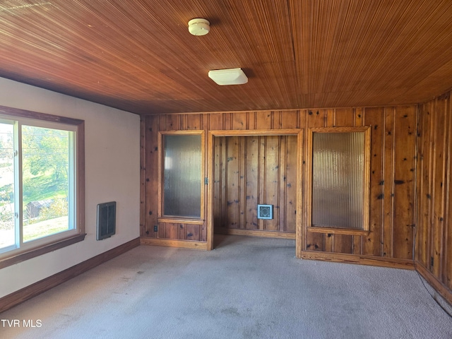 unfurnished room featuring wood ceiling, wood walls, and carpet flooring