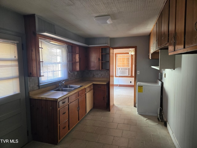 kitchen with washer / clothes dryer, cooling unit, backsplash, sink, and wood walls