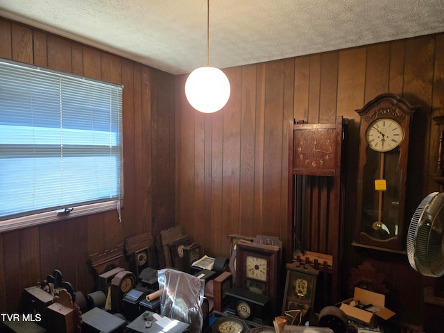 misc room featuring wood walls and a textured ceiling