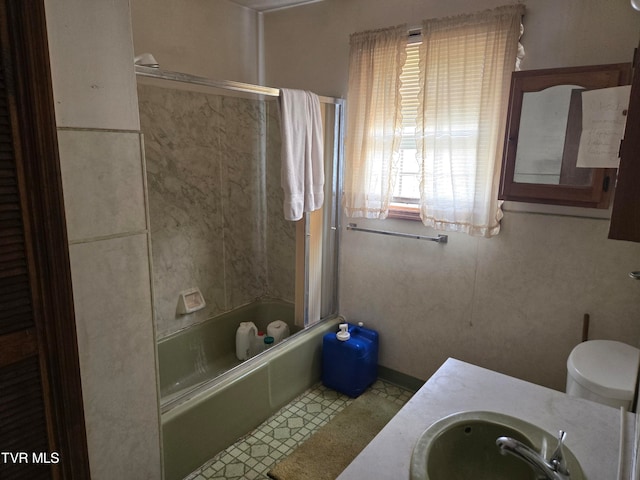 full bathroom with vanity, shower / bath combination with glass door, and toilet