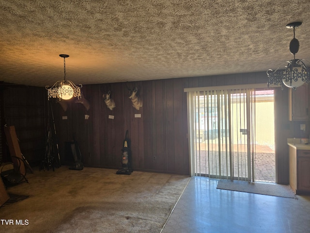 unfurnished dining area with a textured ceiling and wooden walls