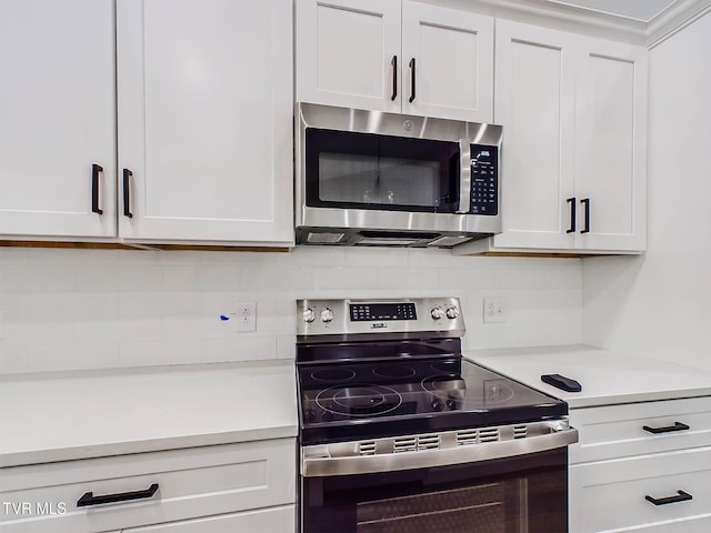 kitchen with white cabinets, appliances with stainless steel finishes, and tasteful backsplash