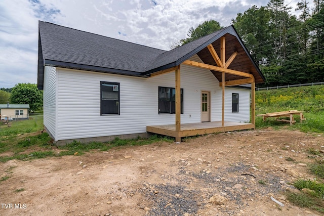 rear view of house featuring a wooden deck