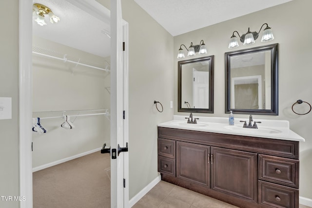 bathroom featuring vanity, a textured ceiling, and tile patterned floors