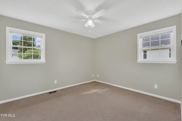 carpeted spare room featuring ceiling fan