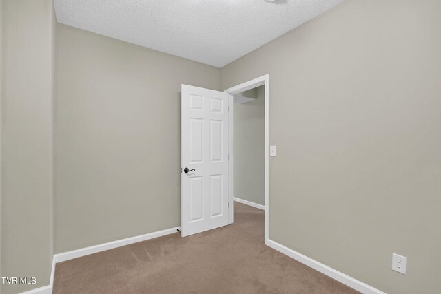 carpeted empty room with a textured ceiling