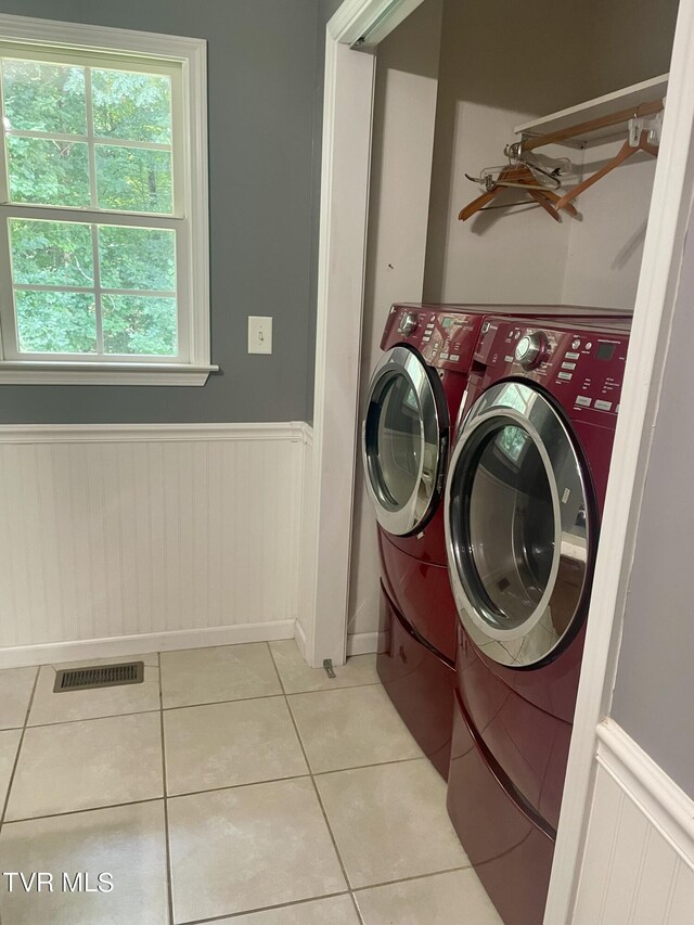 laundry area with light tile patterned floors and washing machine and clothes dryer