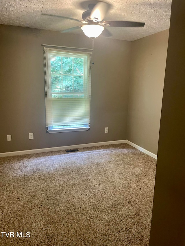 carpeted spare room with a textured ceiling and ceiling fan