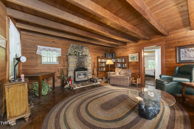 living room featuring beam ceiling, wooden ceiling, a wood stove, and wooden walls