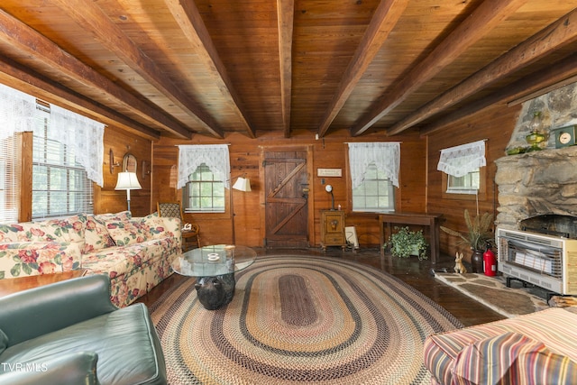 living room featuring heating unit, wooden walls, beamed ceiling, and a healthy amount of sunlight