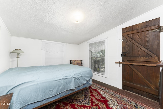 bedroom featuring hardwood / wood-style flooring, lofted ceiling, and a textured ceiling