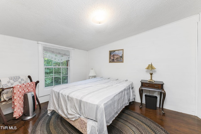 bedroom featuring a textured ceiling, dark hardwood / wood-style floors, and vaulted ceiling