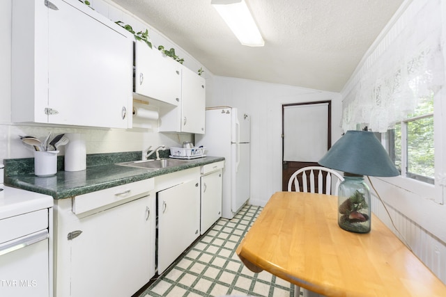 kitchen with lofted ceiling, white appliances, white cabinetry, and sink