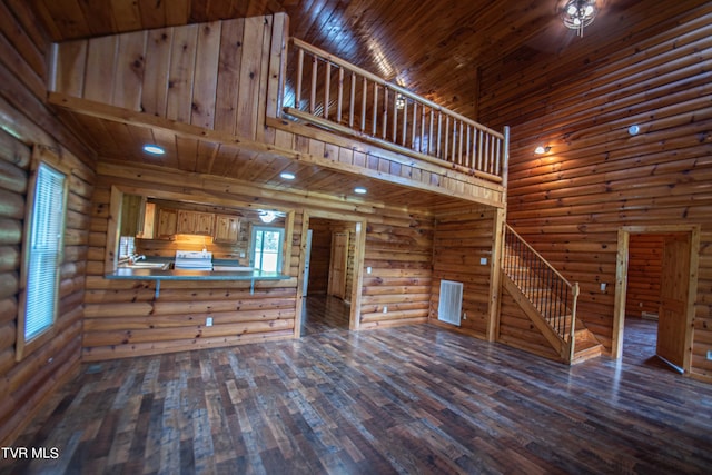 unfurnished living room featuring log walls, high vaulted ceiling, dark hardwood / wood-style flooring, and wood ceiling