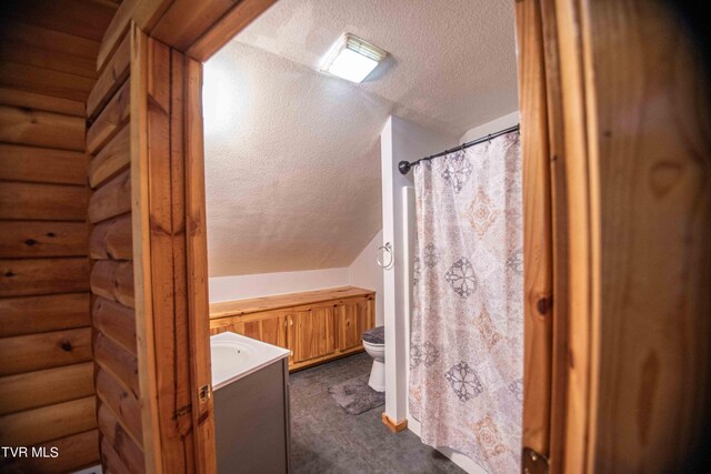 bathroom featuring a textured ceiling, vanity, toilet, and a shower with curtain