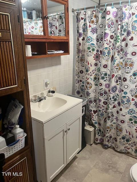 full bathroom with tasteful backsplash, a shower with shower curtain, tile walls, and vanity