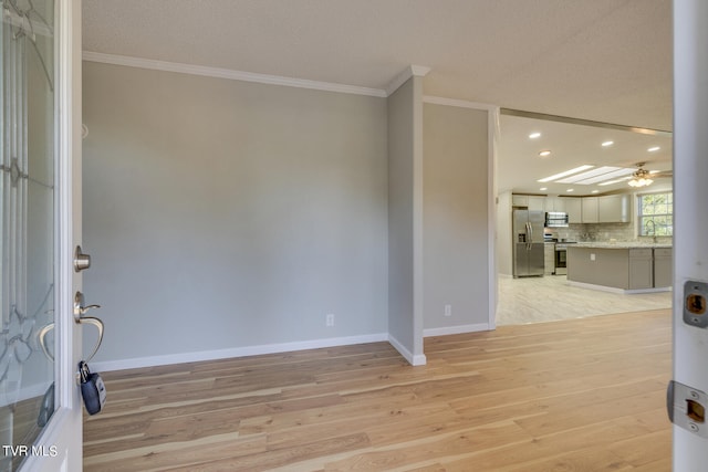 living room featuring ornamental molding, a textured ceiling, ceiling fan, and light hardwood / wood-style floors