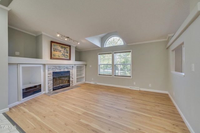 unfurnished living room with lofted ceiling, a fireplace, light hardwood / wood-style floors, and ornamental molding