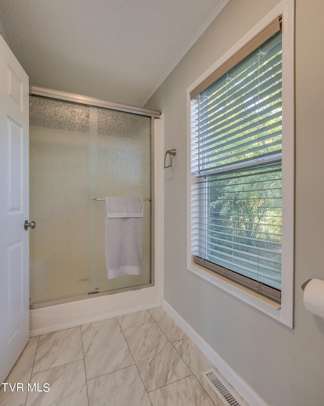 bathroom with a textured ceiling and walk in shower