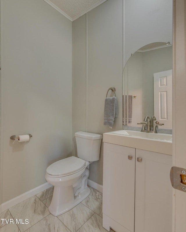 bathroom featuring crown molding, vanity, and toilet