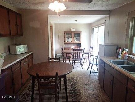 kitchen with a textured ceiling, sink, and ceiling fan