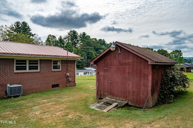 view of outbuilding featuring a yard and central AC