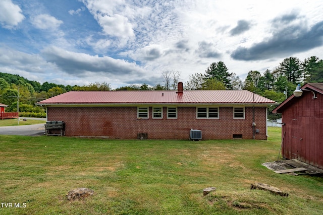 rear view of property with a lawn and central AC