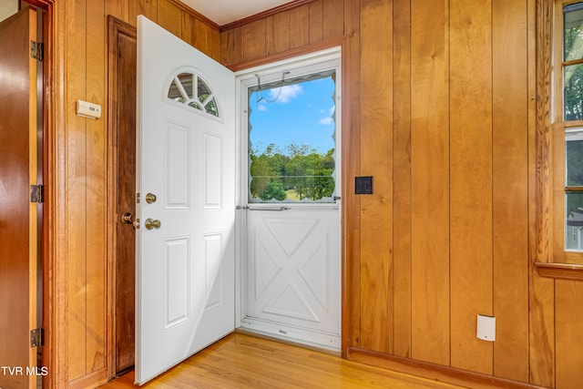 foyer entrance featuring wood walls and light hardwood / wood-style floors